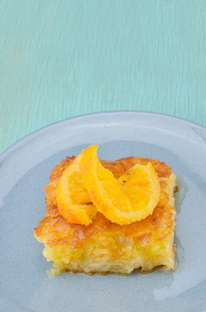 Piece of orange pie in plate with orange twist slice on topの写真素材