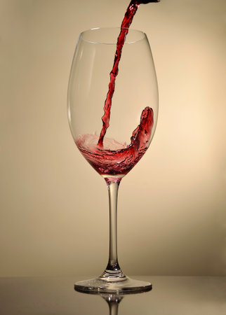 Pouring red wine on a glassの写真素材