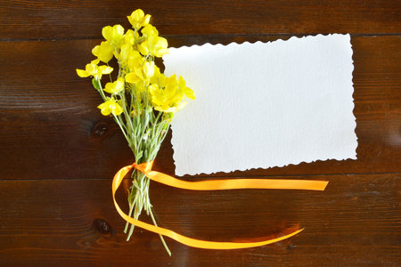 Small bouquet of  yellow wild flowers and blank paperの写真素材