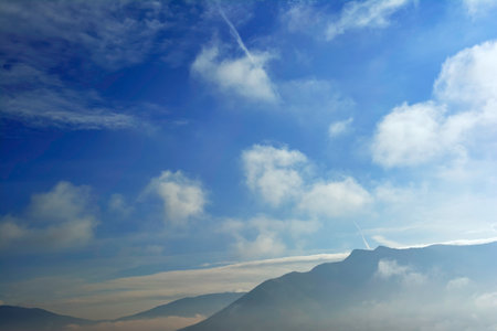 Scenery with mountain surrounded by clouds and fog