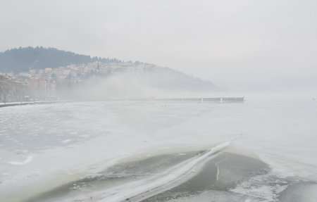 Winter scene with the frozen lake Orestiada in Kastoria,Greece a dull ovecast misty dayの写真素材