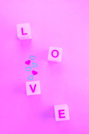 Letters on squares boxes for word love and small hearts on pink backgroundの写真素材