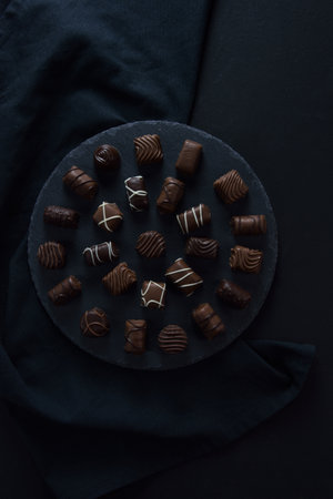 Assortment of chocolate candies on black trayの写真素材
