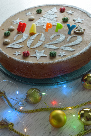 Traditional greek decorated cake for 2022 known as vasilopita, with christmas ornaments and lightsの写真素材