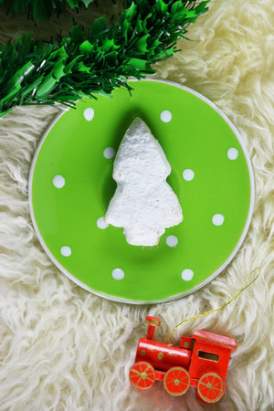 Kourabies in tree shape on green plate with dots and red wooden train ornament and artificial firの写真素材
