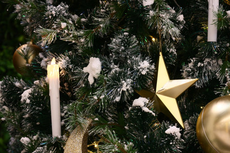 Candle and gold star decorate on Christmas tree.