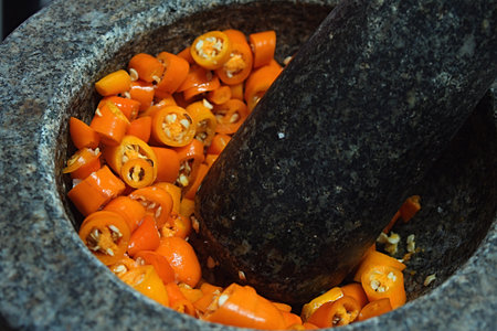 Blending yellow chilli in motar.の写真素材