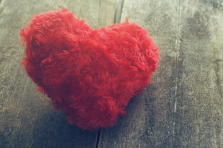 Red heart on wood plate with bright background.の写真素材