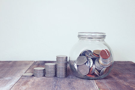 Coin and book bank account and glasses on report document.の写真素材