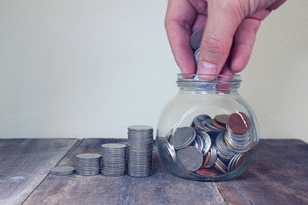 Coin and book bank account and glasses on report document.の写真素材