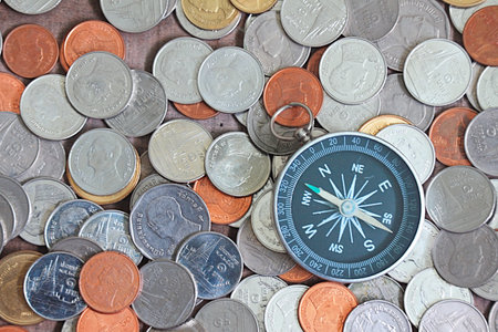 Compss and coins on wood background , finance concept.の写真素材