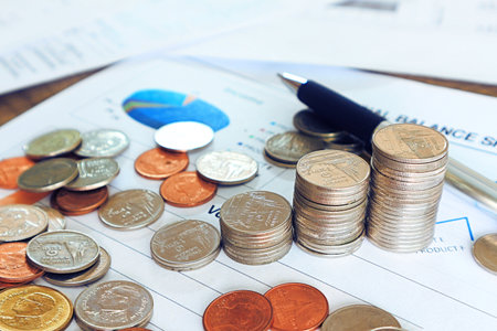 Close up pen and compass and coin stack on income document , finance concept.