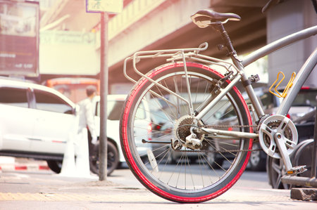 Bicycle at parking space with background traffic steet in the city at "Sukumwit" BangkokThailand.の写真素材