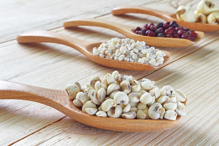 Mix cereal , soy beans , dry millet seed , red beans , lotus seed on spoon with backgeound wood table.の写真素材