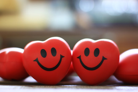 Two red hearts with smile face on bright blur background.の写真素材
