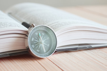 Compass and book on the table. の写真素材