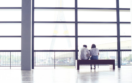 Couple love sitting on the bench and bright background.の写真素材