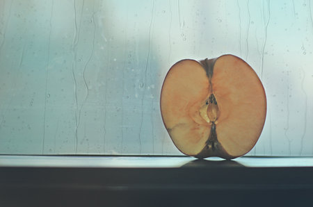 Vintage half apple with background rain drop on windowの写真素材