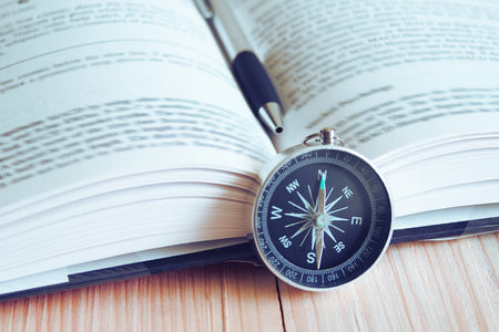 Compass and book on the table. の写真素材
