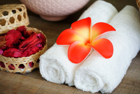 White towels decorate with orange flower near dry aroma rose on spa set table.の写真素材