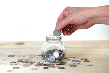 Hand fill coin on saving glass,saving concept.