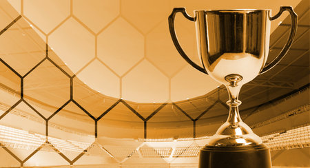 Gold theme trophy with background fade hexagon pattern on stadium,win concept.の写真素材