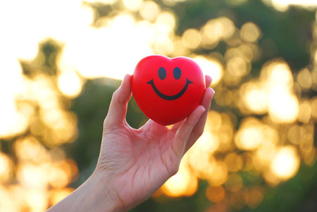 Hand hold red smile heart with bokeh backgroundの写真素材