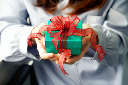 Woman receive surprise green gift box with red ribbon. 