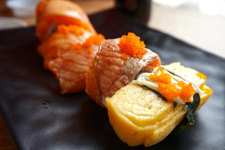 Sushi raw fish in front of rice set on black dish の写真素材