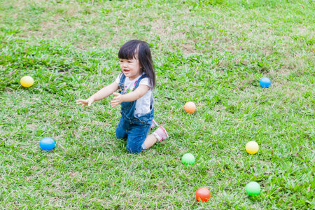 Cute Baby Girl 2-3 Year Old Playing Ball in the gardenの写真素材