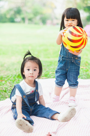 Cute Kids 2-3 Year Old Playing Ball in the gardenの写真素材