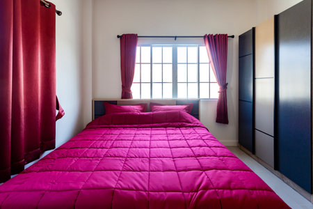 Red Pillow and Red Blanket with Red Curtain in the Bedroom with Ambience Lighting  Interior.の写真素材