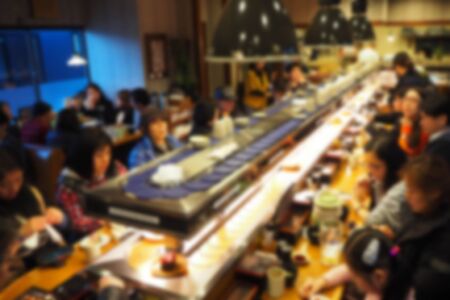 Blurred abstract background of People eating sushi conveyor belt in a Japanese restaurant.の写真素材