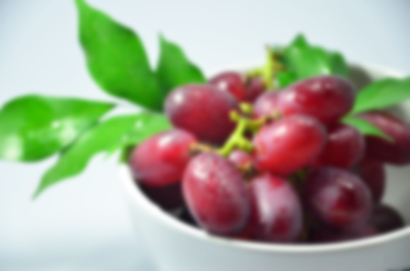 Blurred abstract background of Grapes placed white bowlの写真素材
