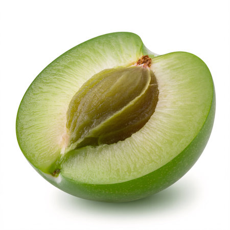 A vibrant green plum, cut in half to reveal its light green flesh and a prominent brown pit, presented against a clean white background.の素材