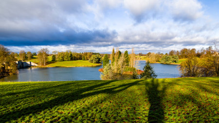 The lake in Blenheim Palace, blue sky with cloudy, peaceful lake and the shadows of trees combined that peaceful landscapeの写真素材