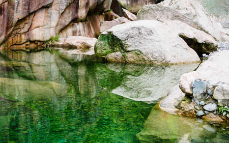 Huihang Ancient Trail Hiking Tour.  lake in mountains between Anhui and Zhejiang with the reflection of big rocks, Chinaの写真素材