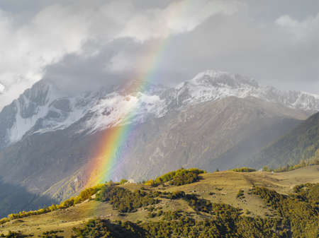 Beautiful mountain rainbow with snow mountains background, Sichuan, China.の写真素材
