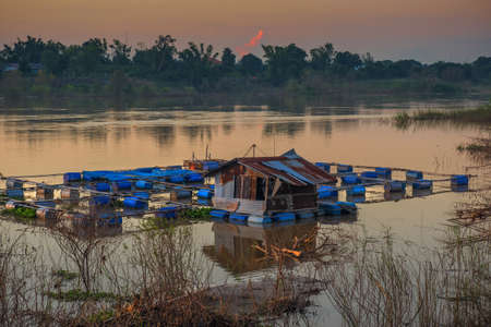 the coop for fish farm in river at sunset of thailandの写真素材