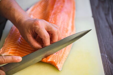 close up chef cutting fresh salmonの写真素材