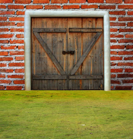 Brick wall with door on grass groundの写真素材