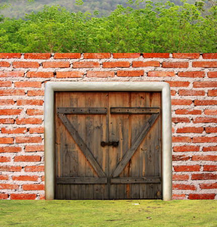 Brick wall with wooden door and treesの写真素材