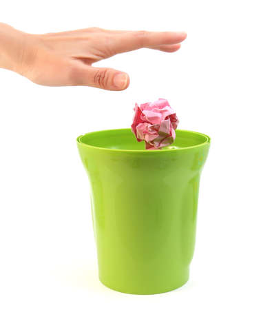 A hand placing paper in plastic bin on white backgroundの写真素材