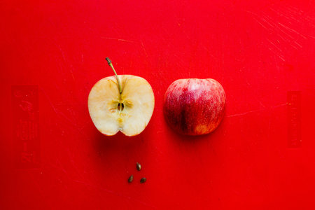 Red apple on a red background. The concept of healthy eating.