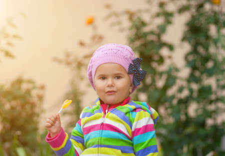 Little girl eats sweet yellow candy. Picture taken when it is backlit.の写真素材