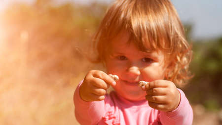 curious little girl holding snailsの写真素材