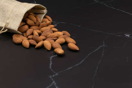 Top view, almond on a wooden spoon, isolated on a white background Organic food concept. Contains vitamins and minerals. Helps to neutralize free radicals. Nourish the castle and brain systemの写真素材