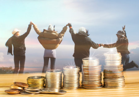 Double exposure The pile of coins placed on the table. With a blurred background of a young woman jumping on a financial concept, saving money for travel or saving money for a young age.の写真素材