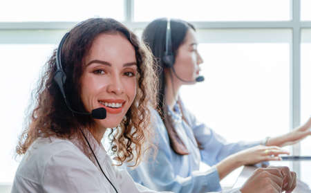 Portrait close up Hispanic woman Smiling female call center operator with headset desktop computer...