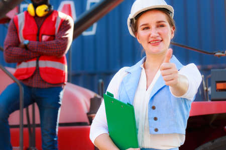 Portrait of a beautiful Caucasian female manager in a white hard hat, Container Loading Supervisor....